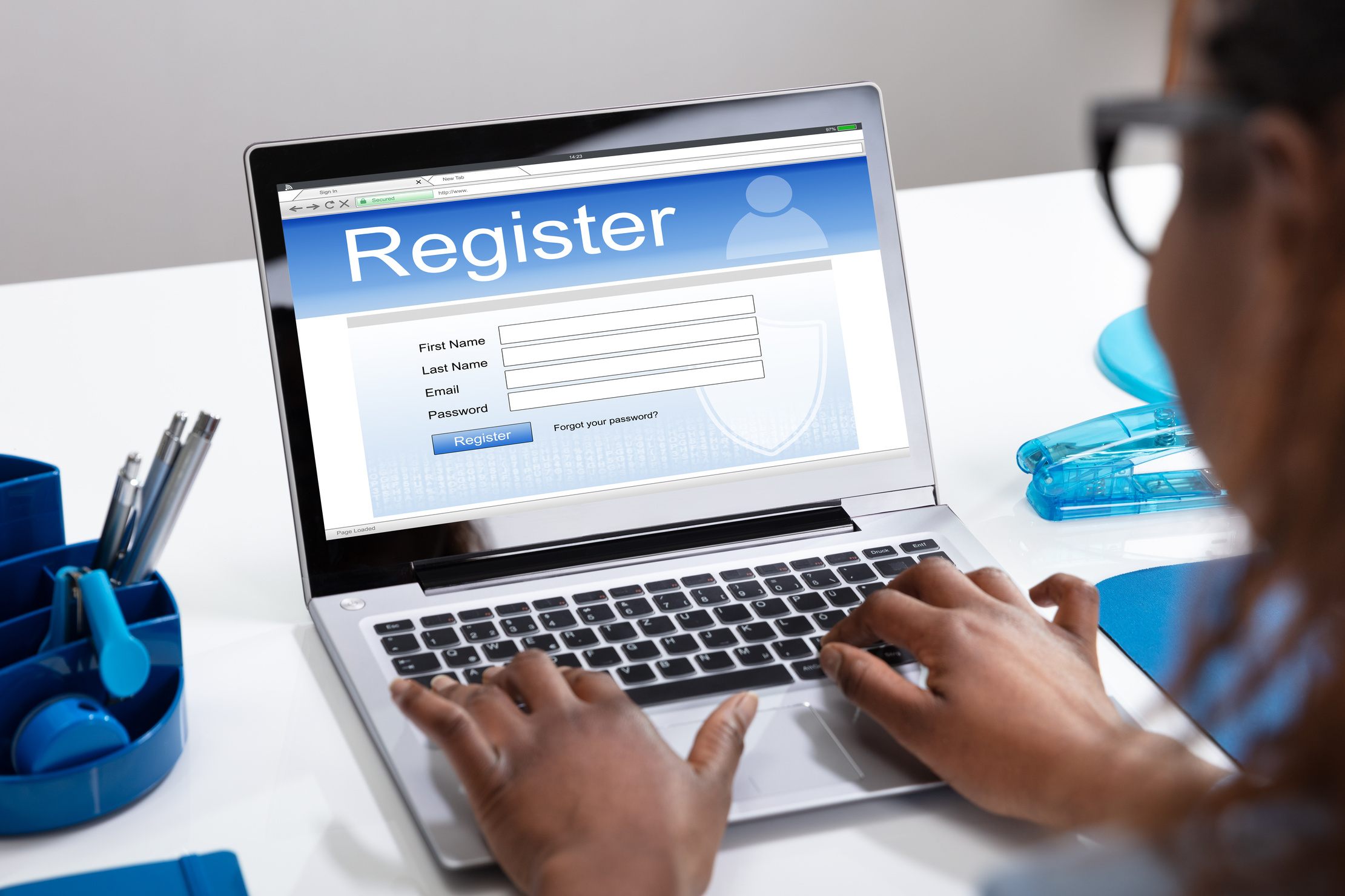 Businesswoman's Hand Filing Online Registration Form On Laptop